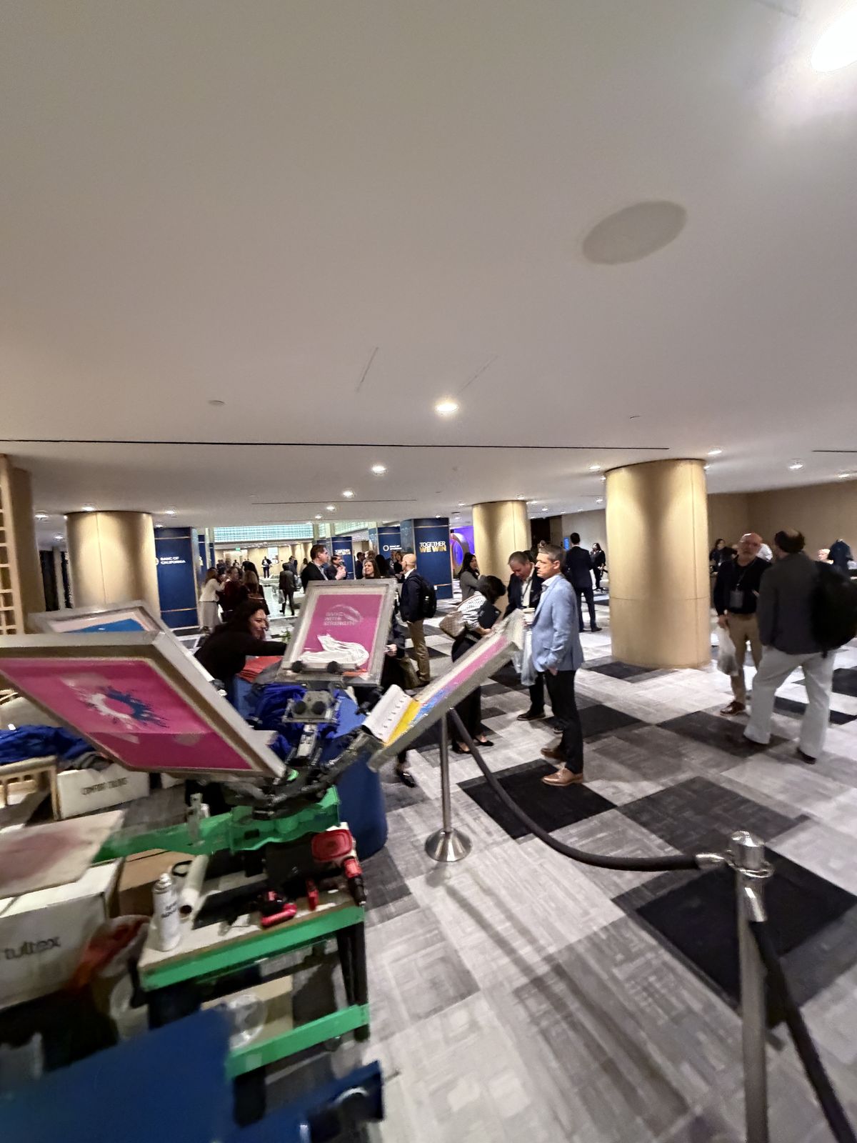 Guests watching custom merch get printed live at a Raleigh event